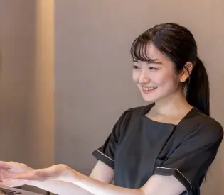 女性が笑顔で受付をしている画像